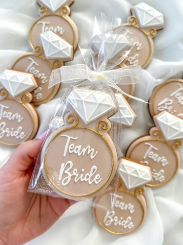 Ręcznie zdobiony piernik korzenny ozdobiony lukrem królewskim w kształcie pierścionka z napisem Team Bride jako idealne podziękowania na wieczór panieński