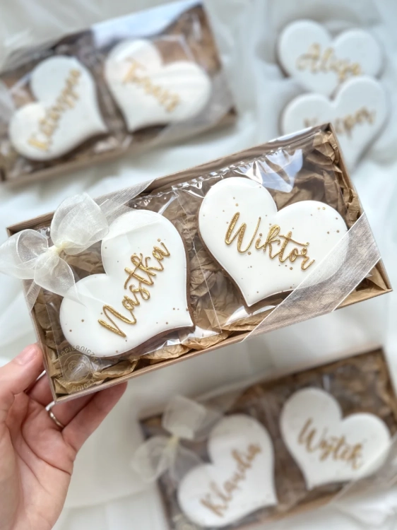 Zestaw prezentowy ręcznie zdobionych pierników na ślub. Pierniki w kształcie serca z personalizowanymi imionami zapakowane w ozdobne pudełko przewiązane kokardką
