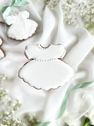 Piernik na komunię w kształcie sukienki zapakowany w celofanowy woreczek z kokardką jako forma podziękowania dla gości komunijnych