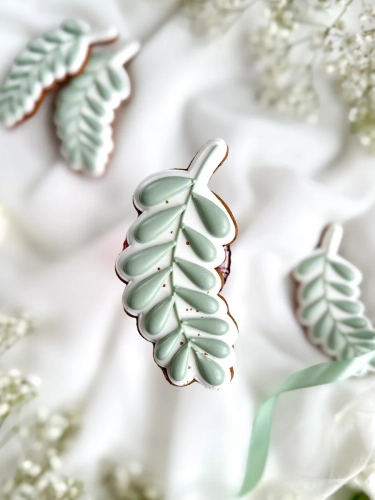 Piernik na komunię w kształcie gałązki oliwnej zapakowany w celofanowy woreczek z kokardką jako forma podziękowania dla gości komunijnych