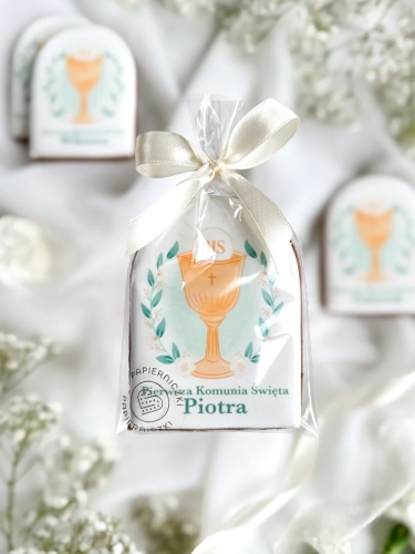 Piernik na komunię z grafiką kielicha i personalizowanym napisem zapakowany w celofanowy woreczek z kokardką jako forma podziękowania dla gości komunijnych