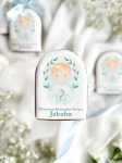 Piernik na komunię z grafiką chłopca i personalizowanym napisem zapakowany w celofanowy woreczek z kokardką jako forma podziękowania dla gości komunijnych