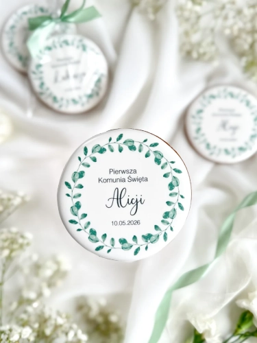 Piernik na komunię z grafiką wianka i personalizowanym napisem zapakowany w celofanowy woreczek z kokardką jako forma podziękowania dla gości komunijnych