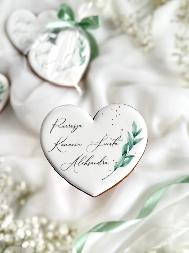 Piernik na komunię w kształcie serca z grafiką gałązki, ze złoceniem i personalizowanym napisem zapakowany w celofanowy woreczek z kokardką jako forma podziękowania dla gości komunijnych
