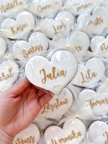 ręcznie lukrowane pierniki w kształcie serca z personalizowanym złotym, imieniem jako wyjątkowe podziękowania dla gości na chrzest czy wesele