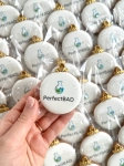 ręcznie zdobione mini pierniczki świąteczne w kształcie bombki z logo firmy przewiązane ozdobną kokardką jako słodycze reklamowe lub firmowe upominki